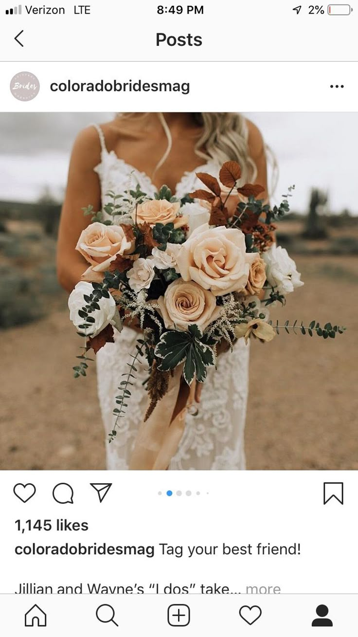 a woman holding a bouquet of flowers on top of her wedding day in the desert