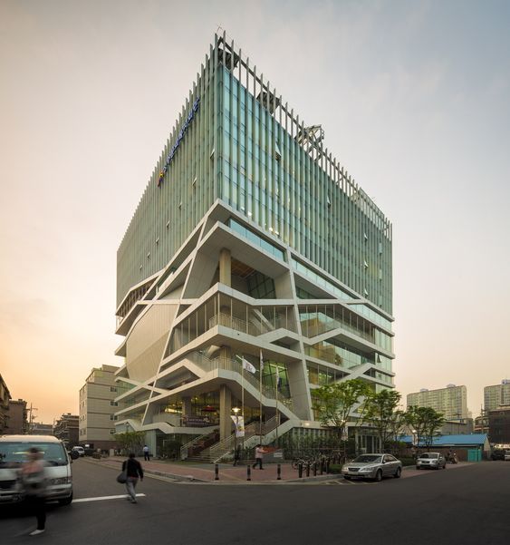 a very tall building sitting on the side of a road next to a busy street