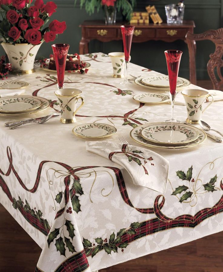 a dining room table set with christmas decorations and red roses in vases on it