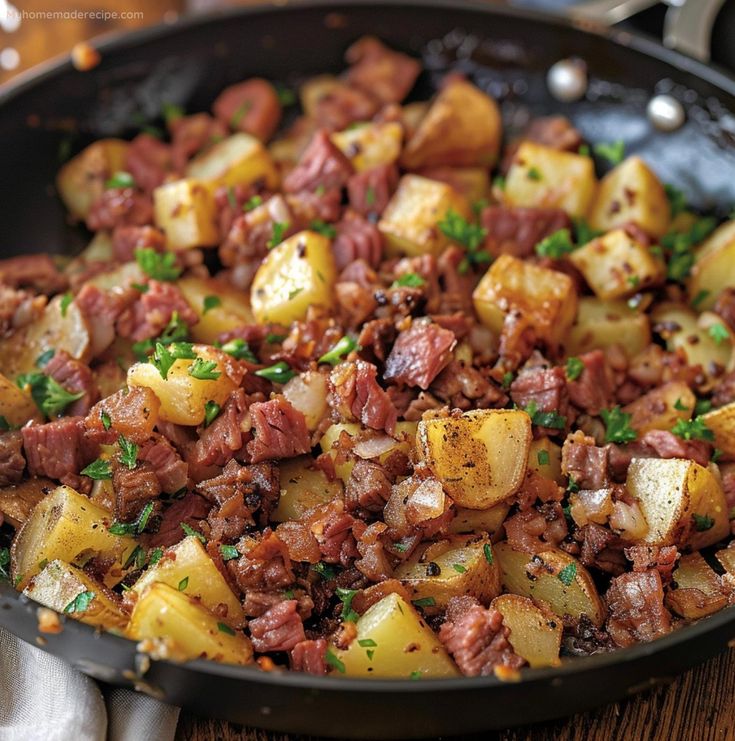 a skillet filled with cooked potatoes and meat