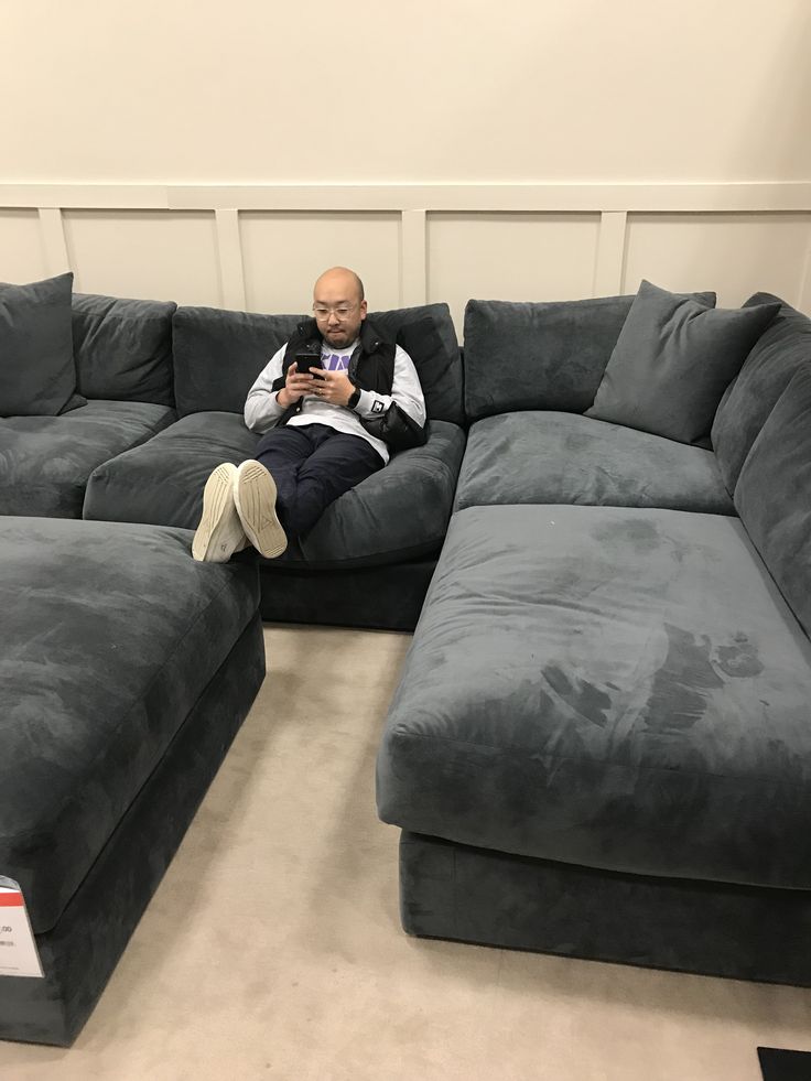 a man sitting on top of a gray couch