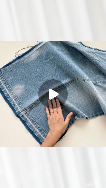 someone is holding onto an old pair of jeans with a white triangle in the middle