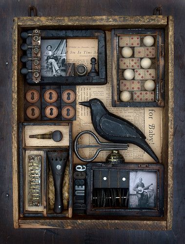 an assortment of old fashioned items are displayed in a shadow box on a wooden surface