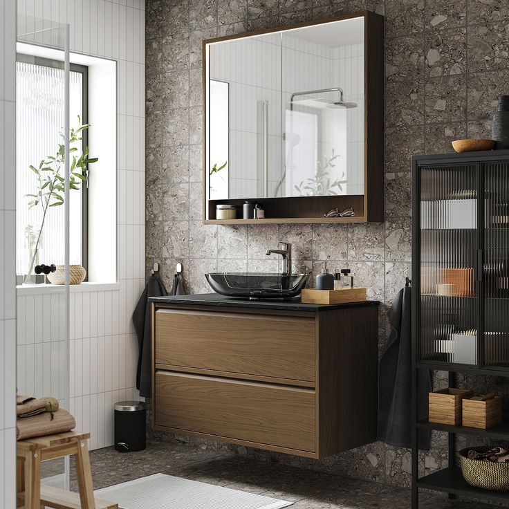 a bathroom with a sink, mirror and shelves on the wall next to it in front of a window