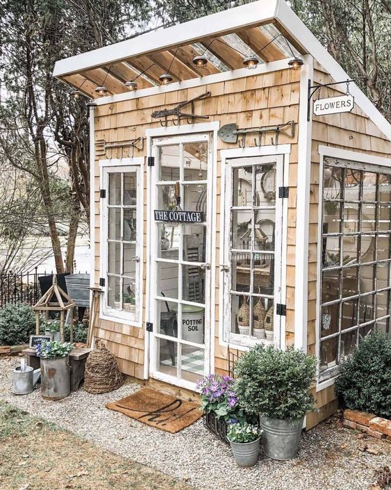 a small wooden building with glass doors and windows