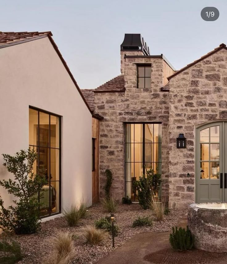 a stone house with green doors and windows