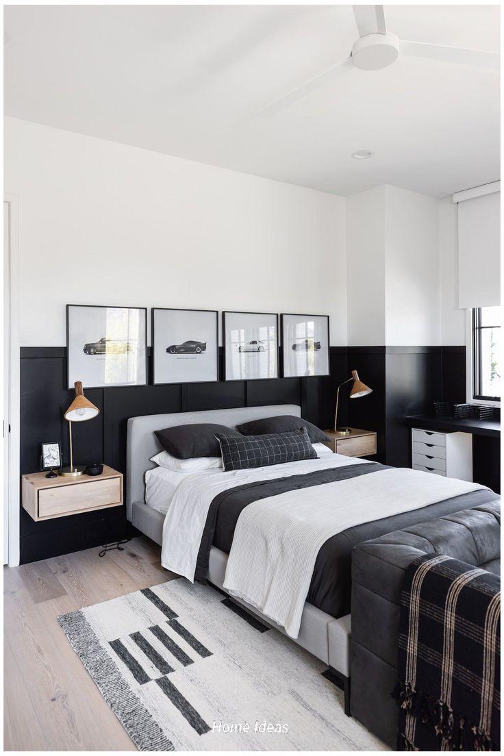 a black and white bedroom with pictures on the wall