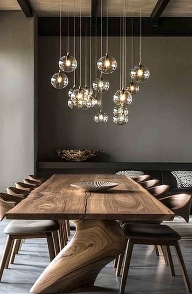 a wooden table with chairs and lights hanging from the ceiling