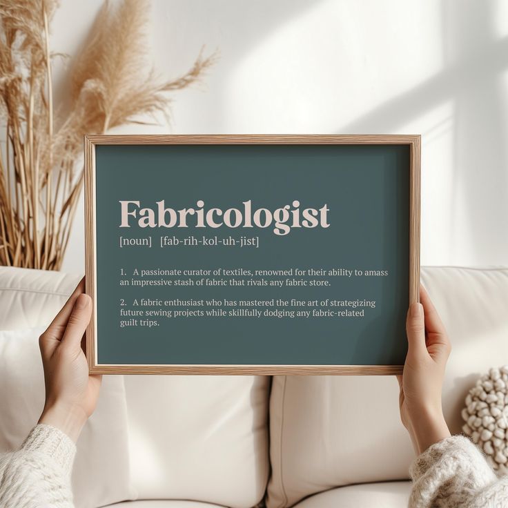 a person holding up a sign that says fabricolist on it in front of a white couch