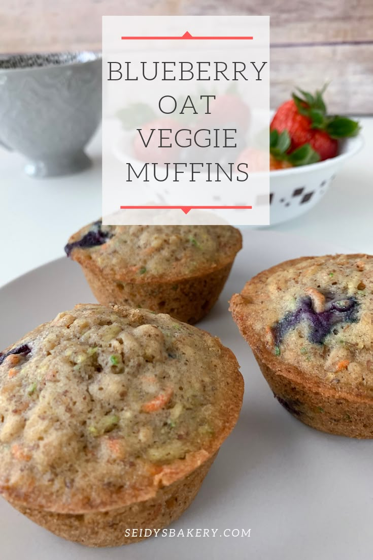 three blueberry oat veggie muffins on a plate with strawberries