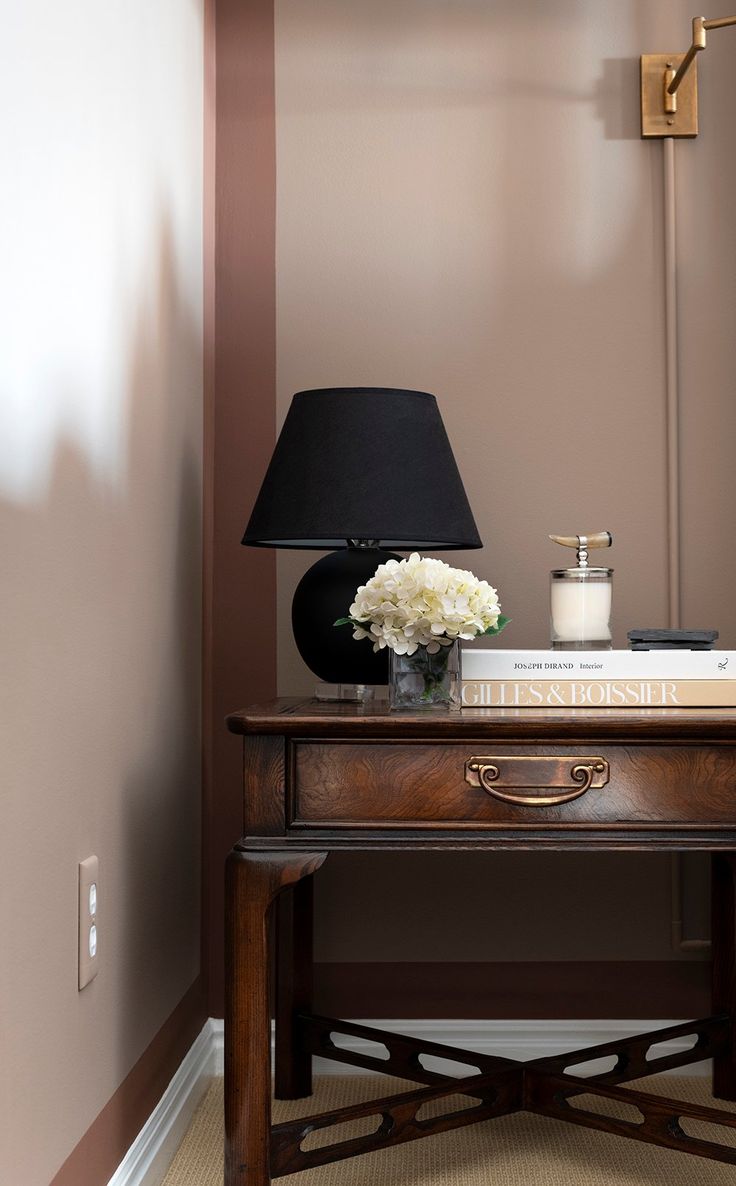 a desk with a lamp and flowers on it