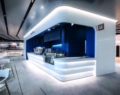 the interior of a modern restaurant with white and blue accents on the walls, along with tables and chairs