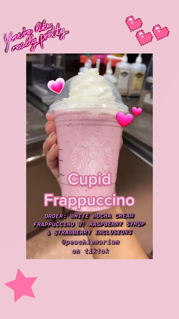 a pink cup with whipped cream and hearts on it in front of a pink background