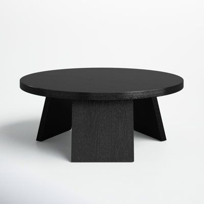 a black round table sitting on top of a white floor