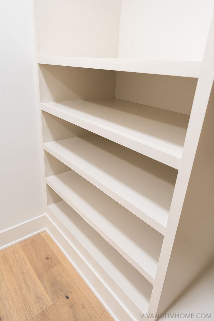 an empty white book shelf in a room