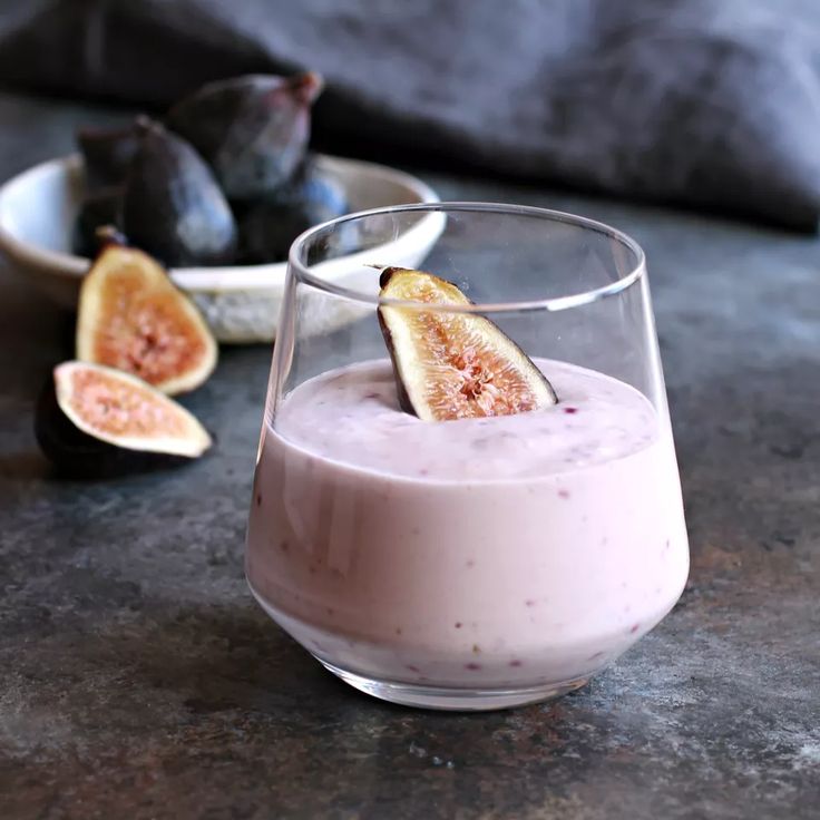 a smoothie in a glass with figs on the side