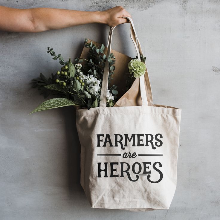 "Farmers Are Heroes" Where would we be without them? Sing their praises with this unique vintage-inspired typographic tote bag. Constructed with a nice, soft cotton canvas, this tote is the perfect size for a quick run to the library or farmers market. Designed with love and printed by hand, this bag makes a great gift for anyone who loves farmers and the valuable work they do! #farmers #farmersmarket #totebag #reusablebag #tote #canvas #farmersareheroes #theoysterspearl #shopsmall Farm Shirts, Farmers Market Display, Boho Canvas, Closet Clutter, Farmers Market Bag, Brown Leather Backpack, Eco Gifts, Handmade Tote, Tote Bags Handmade