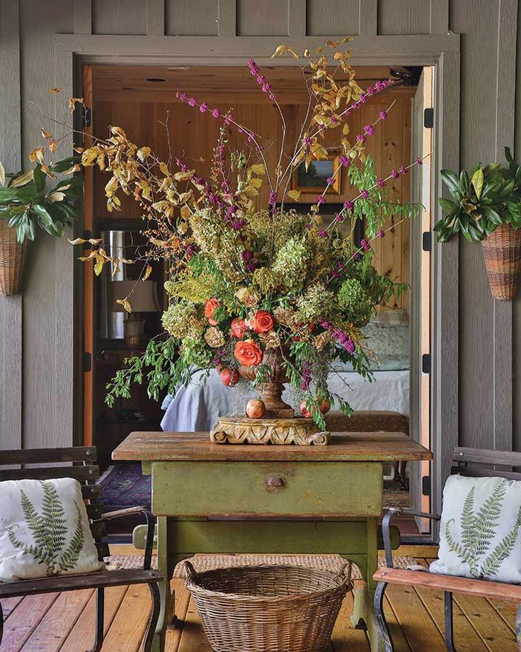 a table with flowers on it in front of a door