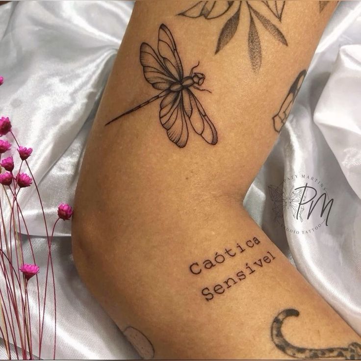 a woman's arm with tattoos and writing on it