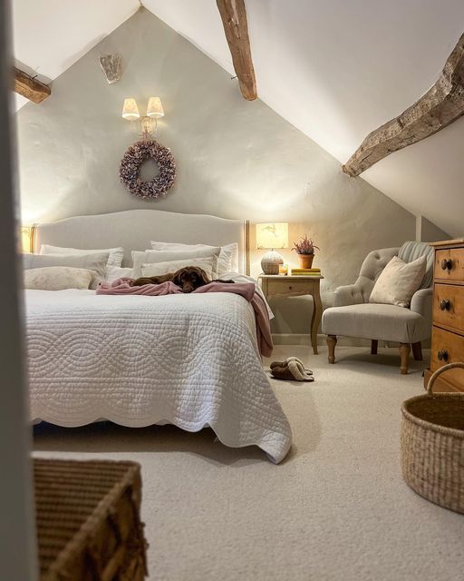 a bedroom with a bed, chair and dresser in the corner next to an attic