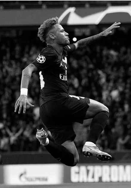 a black and white photo of a soccer player jumping in the air