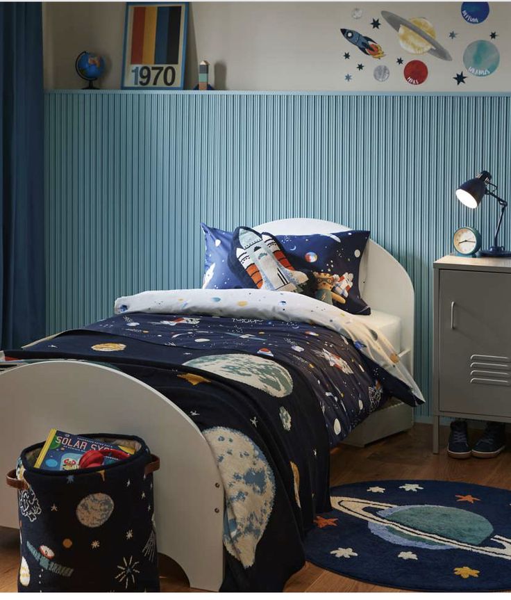 a child's bedroom decorated in blue and white with space themed bedspreads