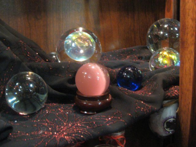 an assortment of soap bubbles sitting on top of a black cloth next to a wooden cabinet