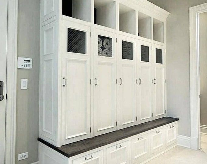 a room with white cabinets and drawers in it