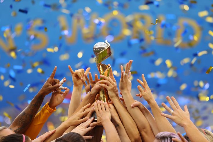 many people are holding up a trophy in front of confetti