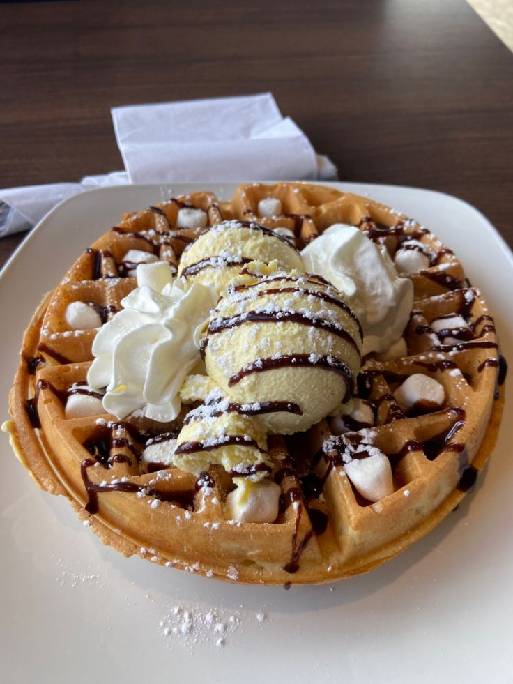 a waffle topped with ice cream and chocolate sauce