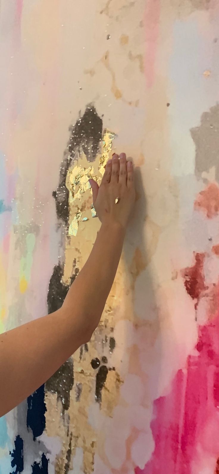 a person is painting on the wall with colorful paint