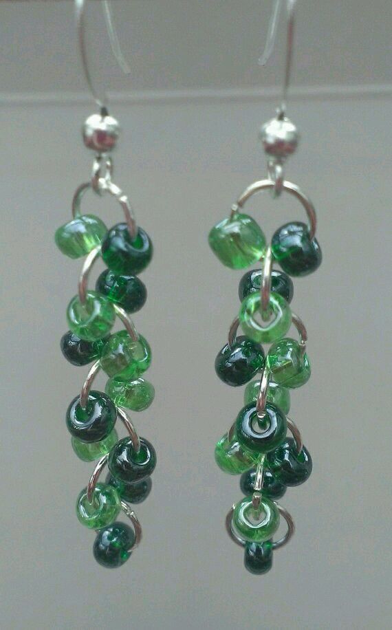 green glass beaded earrings hanging from hooks