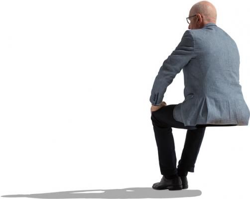 a man sitting on top of a chair with his back turned to the camera and looking down