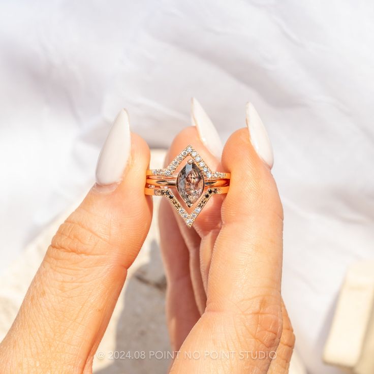 a woman's hand holding an engagement ring with a diamond set in the middle