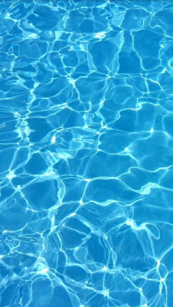 an empty swimming pool with blue water and sunlight reflecting off the surface on the bottom