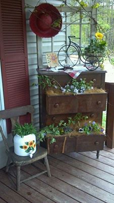 a wooden chair sitting on top of a porch next to a potted planter