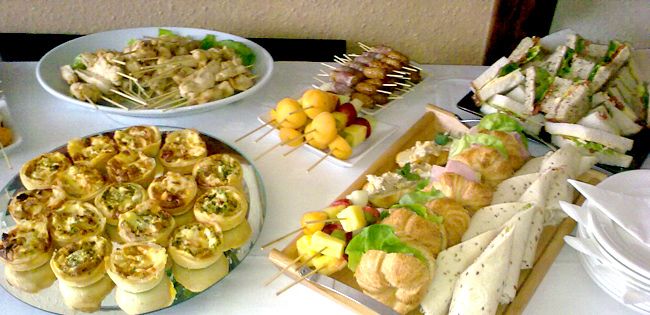 an assortment of appetizers and snacks on a white table cloth covered with napkins