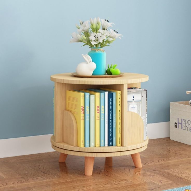 a small wooden table with books on it and a vase full of flowers in the corner