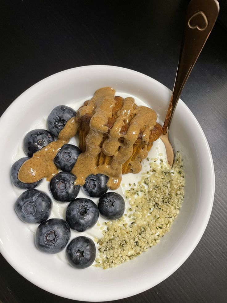 a white plate topped with blueberries and granola