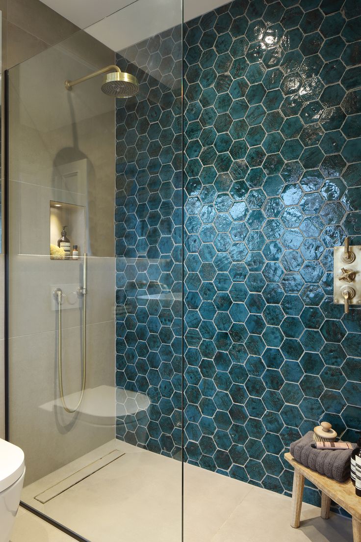 a bathroom with a glass shower door next to a toilet