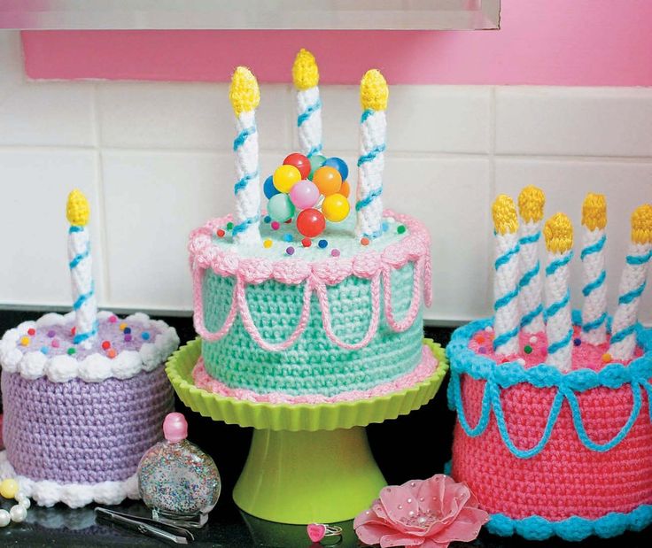 crocheted birthday cakes with candles and candy in them on a kitchen countertop