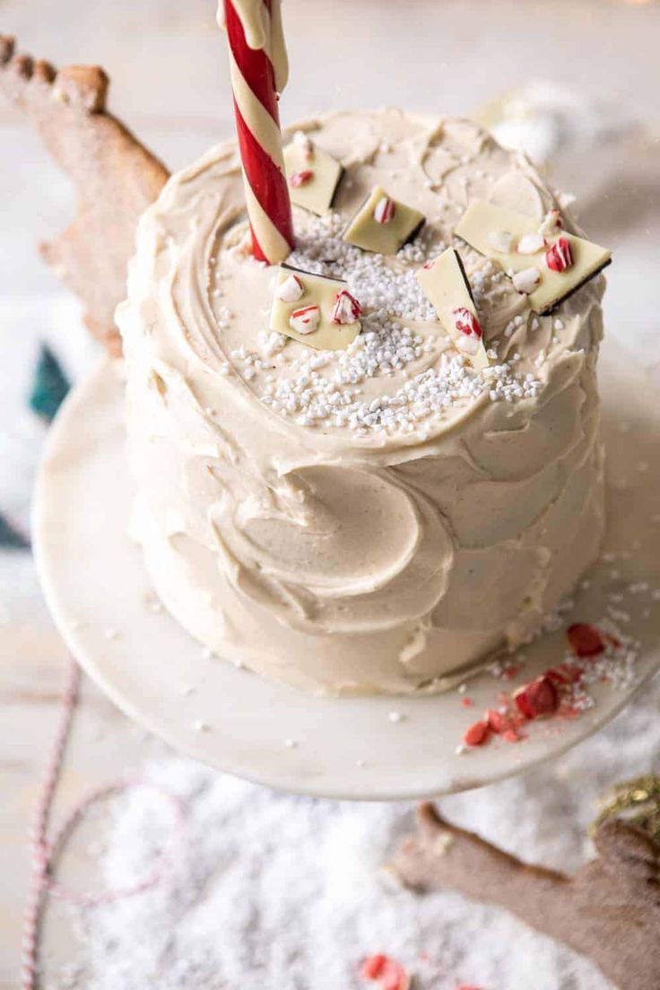 a birthday cake with white frosting and a single candle sticking out of the top