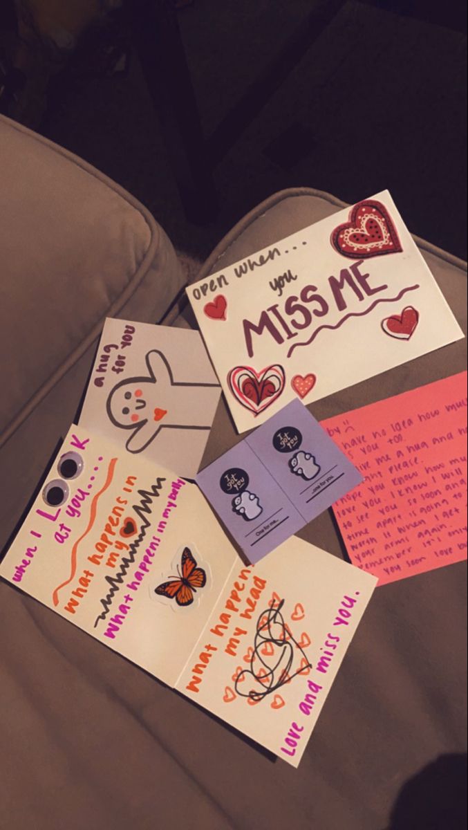 some cards are laying on the couch with hearts and other things to write in them