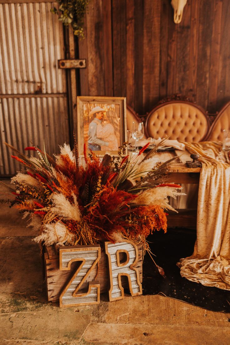 two wooden letters sitting on top of a table next to a vase filled with flowers