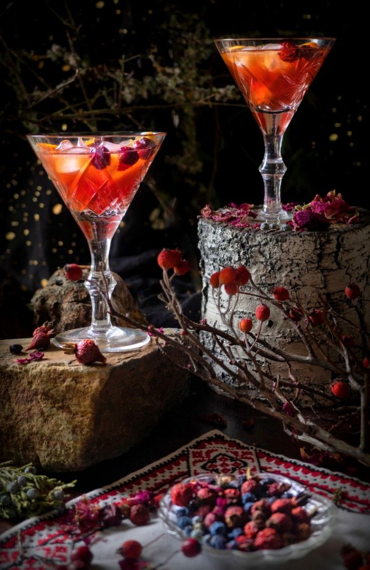 two glasses filled with drinks sitting on top of a table