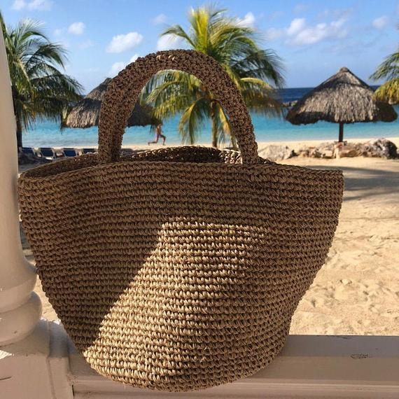 Unique piece handmade specially for you!This beautiful tote is handmade by artisans from Santander, Colombia. 100% made of Fique natural fiber, a plant similar to Agave, it is the perfect summer accessory to be used out in the city or to spend a day at the beach. With two easy to carry handles, you will want to carry it around everywhere you go!Approximate Dimensions:Width (Top): 17.3” / 44 cmHeight: 10" / 25 cmStrap drop: 4.8"/ 12 cmAll of our bags are 100% handmade from natural fibers. Please Natural Bucket Bag With Braided Handles For Market, Fair Trade Straw Bag For Beach, Handwoven Basket Shoulder Bag For Vacation, Summer Bucket Bag With Open Weave In Natural Fiber, Bohemian Beach Bucket Bag In Natural Fiber, Beachy Woven Bags In Natural Color, Handmade Summer Basket Bag, Summer Casual Use Straw Bucket Bag, Summer Handmade Natural Fiber Shoulder Bag