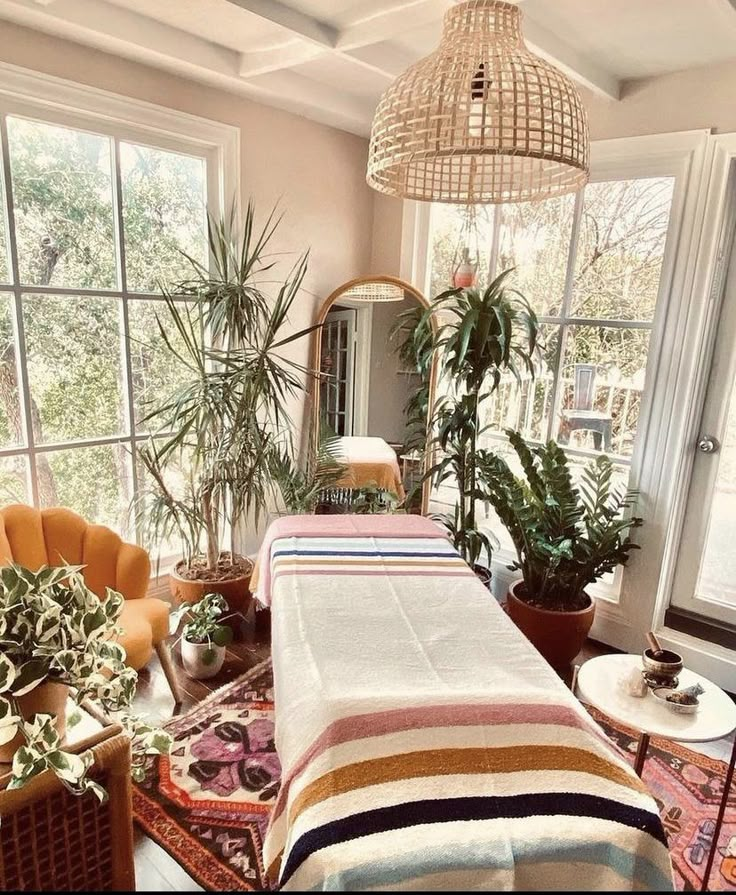 a bed sitting in the middle of a bedroom next to two chairs and potted plants