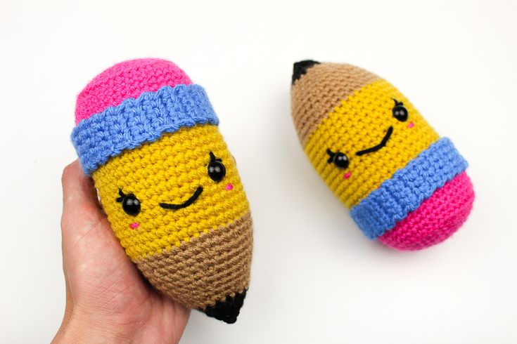 two crocheted pencils with faces on them