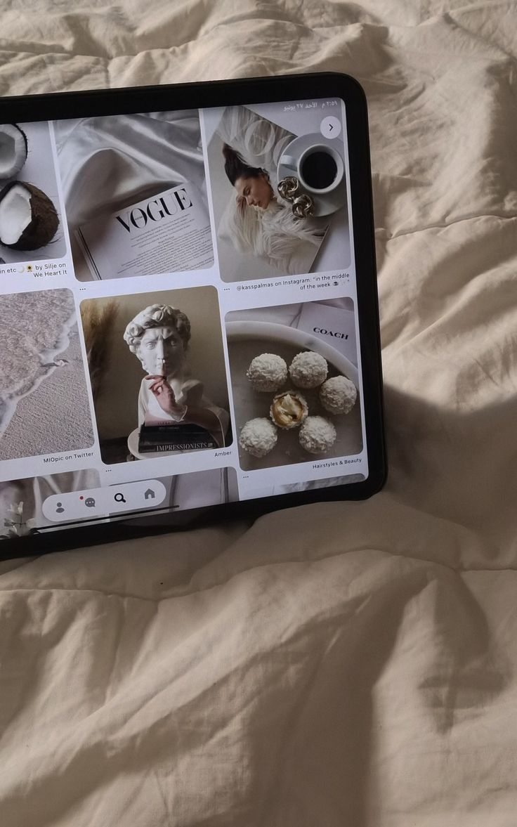 a tablet with pictures on it sitting on a bed