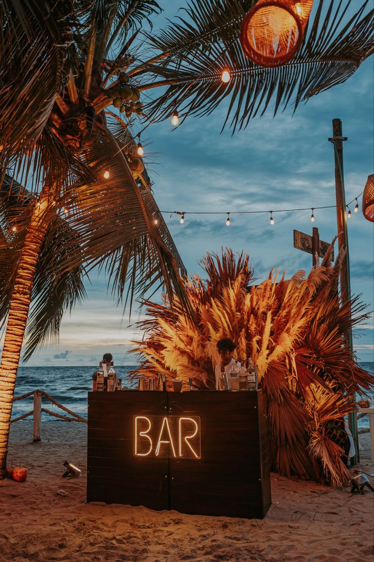 a bar sign sitting on top of a sandy beach